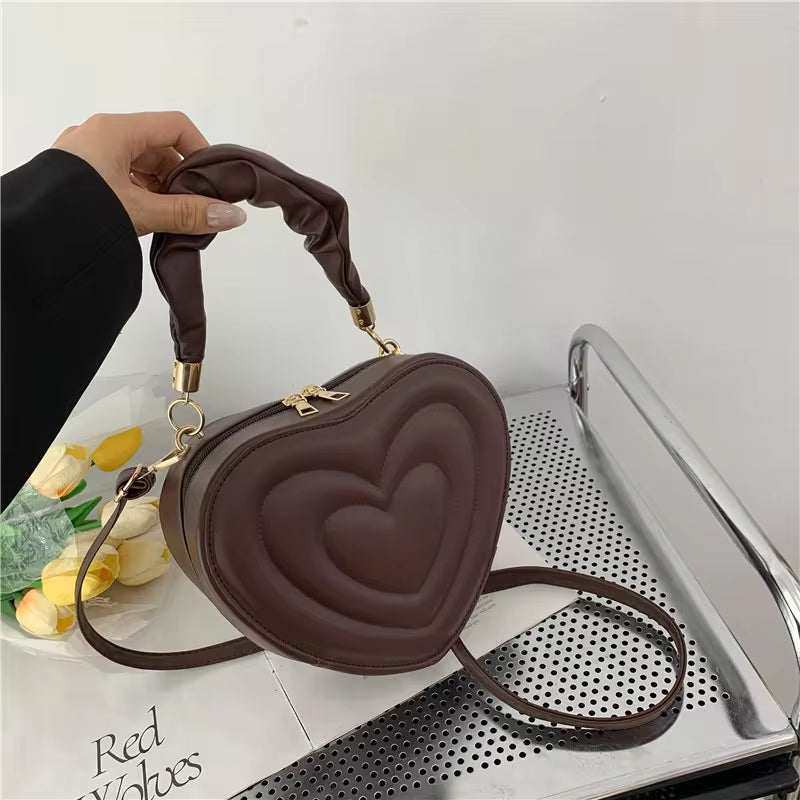 Heart-shaped PU leather shoulder bag in brown with top handle and crossbody strap.