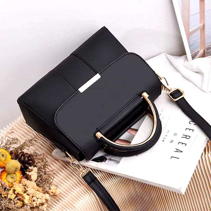 Small black PU leather handbag for women with gold accents on shoulder strap.