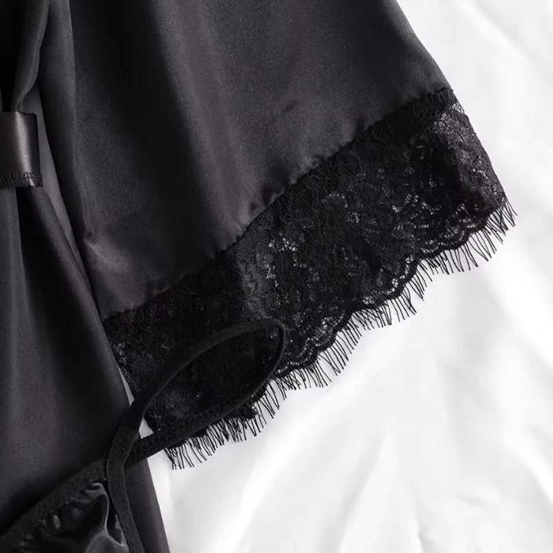 Black satin and lace fabric detail from sexy 4-piece underwear set.