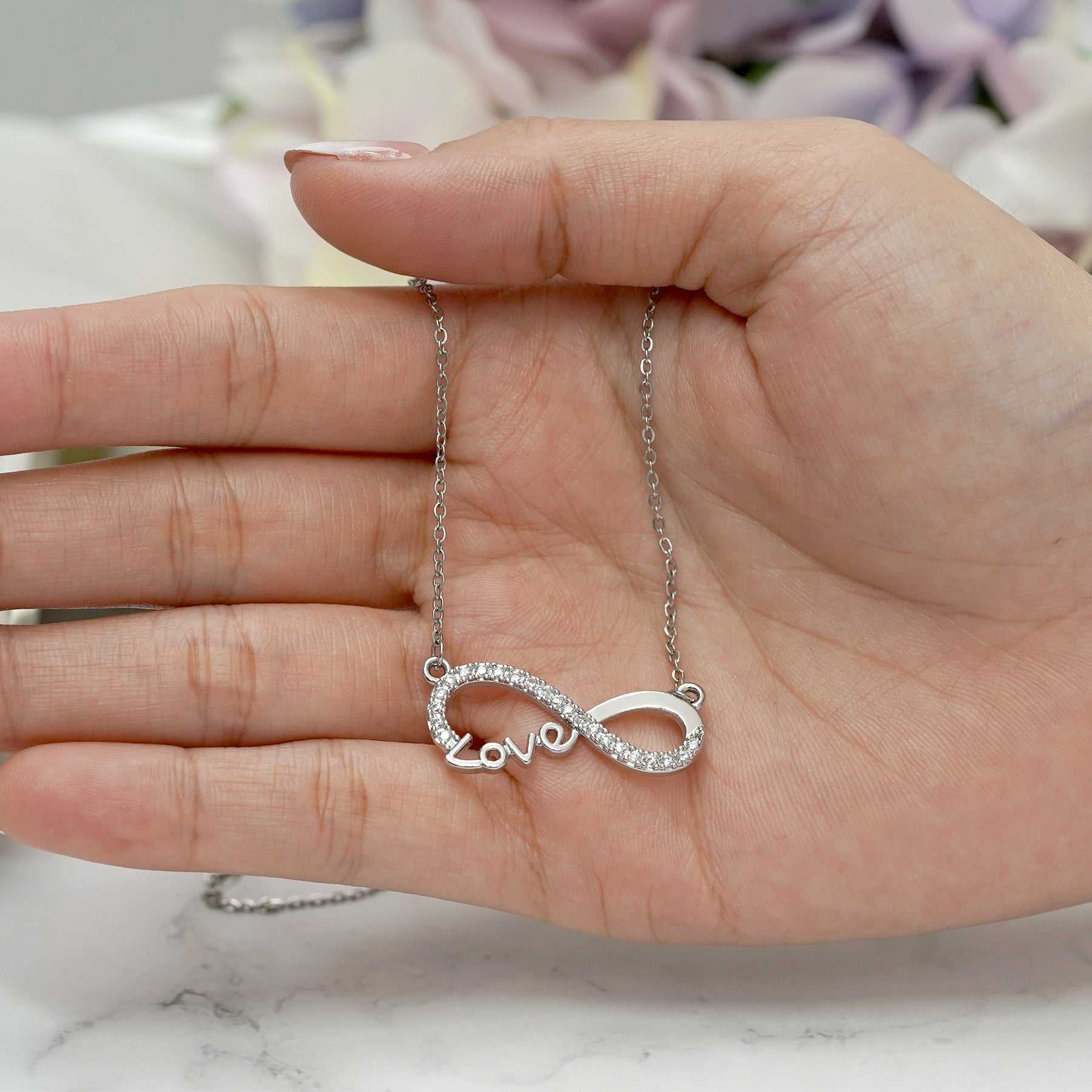 Infinity Love Pendant Necklace in silver with cubic zirconia, symbolizing boundless love; perfect anniversary gift for her.