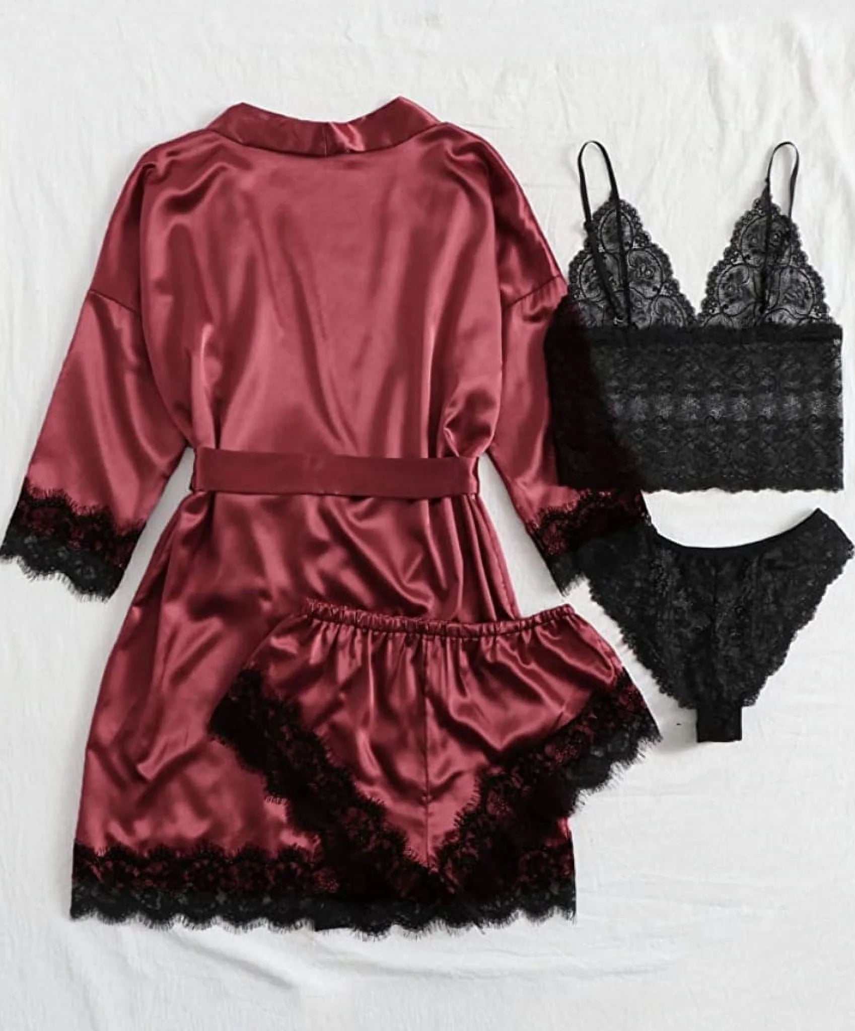 Women satin and lace pajama set featuring a burgundy robe, lace top, and shorts.