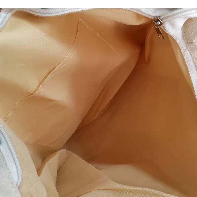 Interior view of large canvas shoulder bag showing spacious compartments.