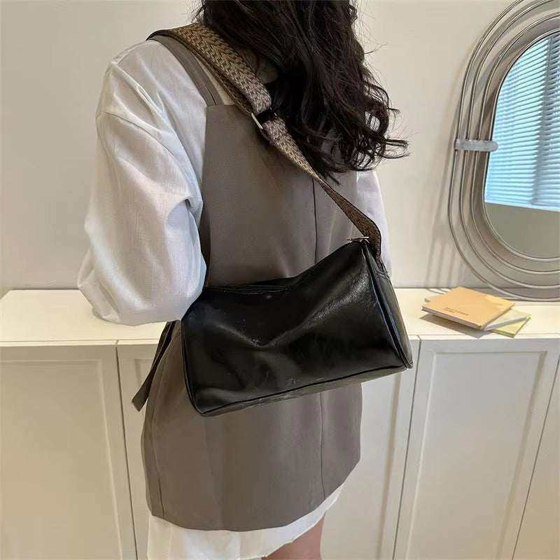 Vintage PU leather crossbody bag in classic Boston style, worn by a woman.