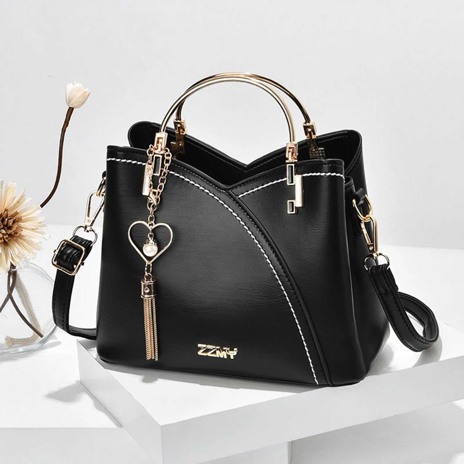 Stylish black handbag with gold accents, large capacity, versatile for shoulder or crossbody use.