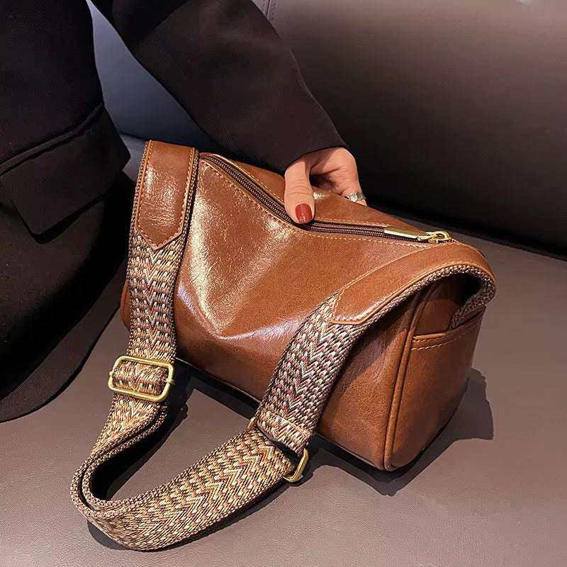 Vintage brown leather crossbody bag with adjustable strap, perfect for stylish convenience.