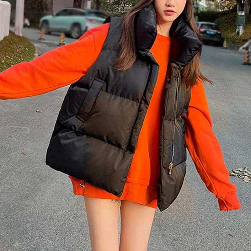 Women's black windproof vest coat with stand collar, styled over an orange hoodie, showcasing casual outerwear for autumn and winter.