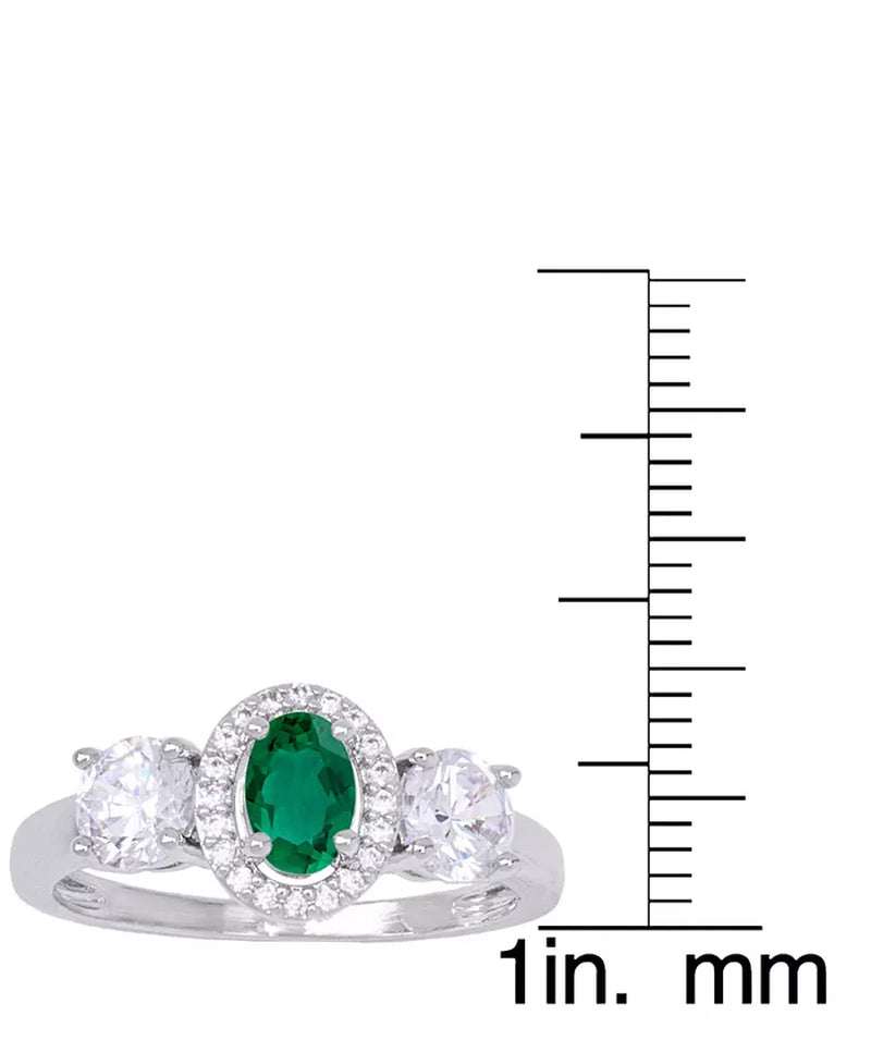 Simulated emerald oval halo ring in silver plate next to a ruler for size reference.