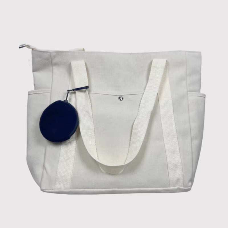 Canvas shoulder bag with large capacity, suitable for work and commuting, featuring durable material and spacious design.