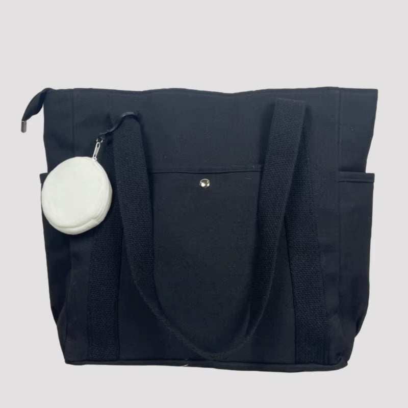 Large black canvas shoulder bag with a round white pouch attached.